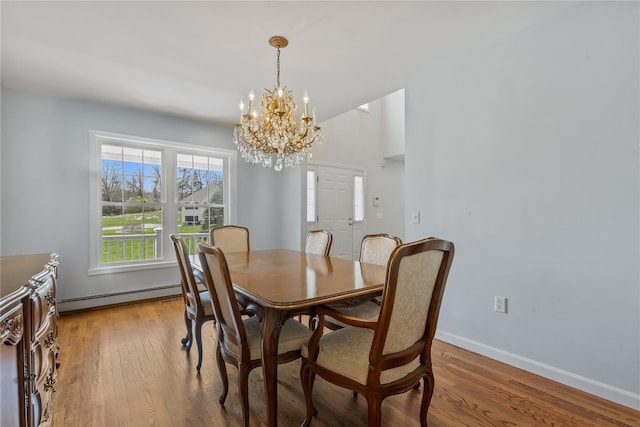 dining space featuring baseboards, a notable chandelier, baseboard heating, and light wood-type flooring