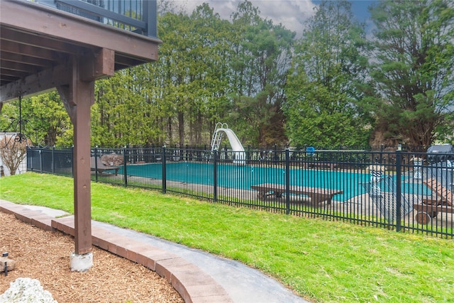 view of swimming pool with a fenced in pool, a water slide, fence, and a lawn