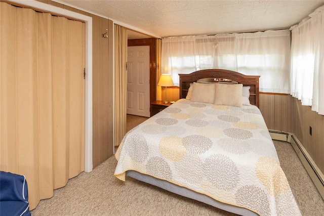 carpeted bedroom with a baseboard radiator and wooden walls