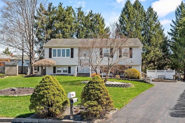 split foyer home with fence and a front yard