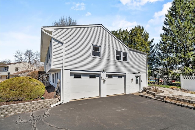view of side of property with driveway and a garage