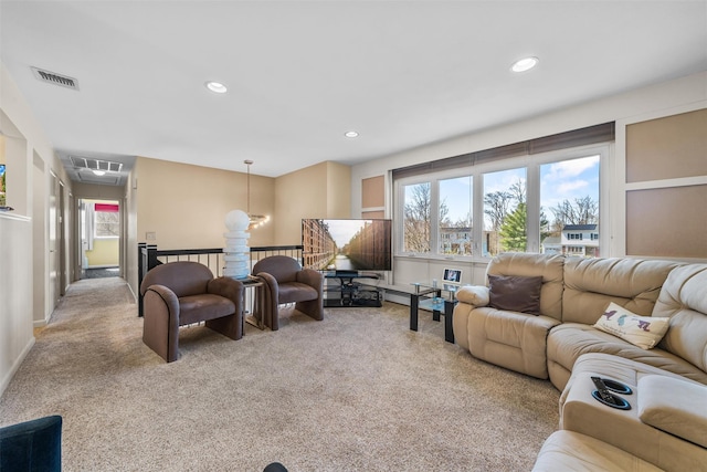 living area with attic access, light colored carpet, and a healthy amount of sunlight