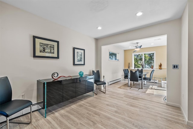 sitting room featuring a baseboard radiator, baseboards, and wood finished floors