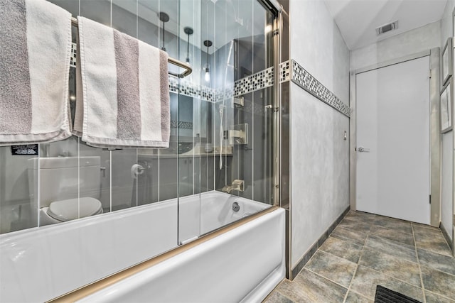 bathroom featuring baseboards, visible vents, stone finish flooring, and shower / bath combination with glass door