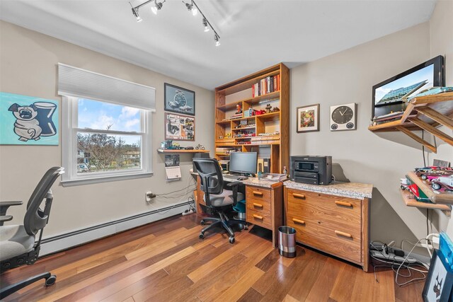 office area with baseboard heating, rail lighting, and wood finished floors