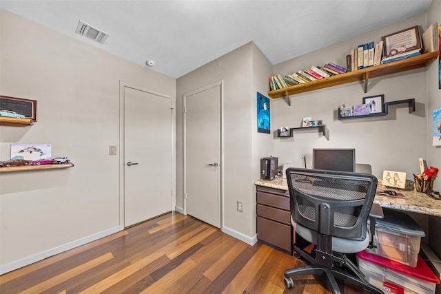 office featuring wood finished floors, visible vents, and baseboards