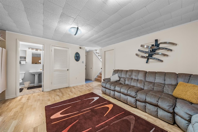 living room featuring stairway, wood finished floors, and visible vents