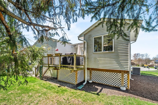 back of property featuring a wooden deck, a yard, cooling unit, and stairway