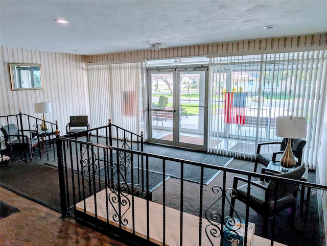 interior space with concrete floors, a healthy amount of sunlight, and french doors