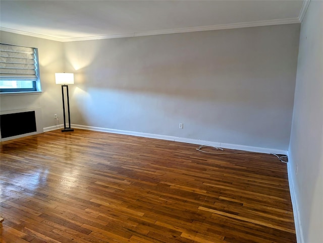spare room featuring baseboards, dark wood-style flooring, and crown molding