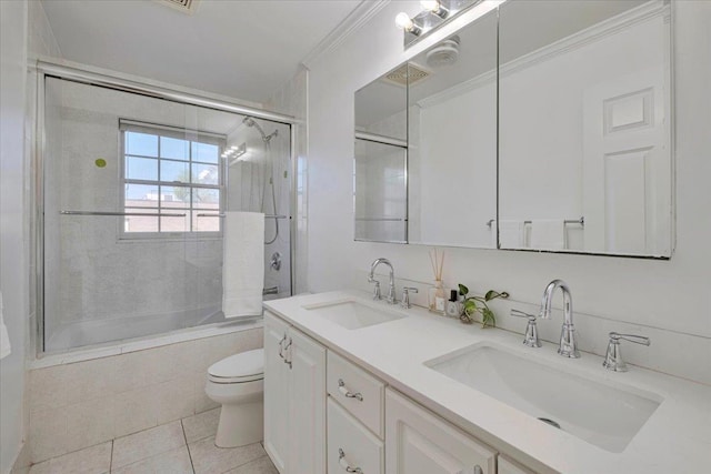 bathroom with toilet, tile patterned floors, combined bath / shower with glass door, and a sink