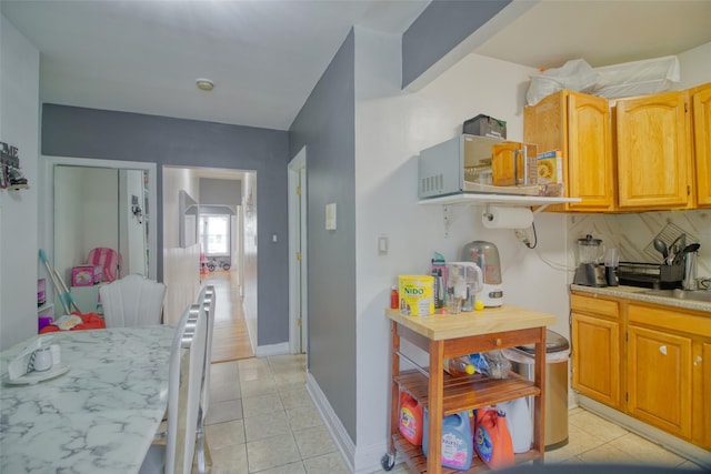 97-69 Corona Ave, Corona, NY 11368 - kitchen with light countertops, light tile patterned floors, and backsplash