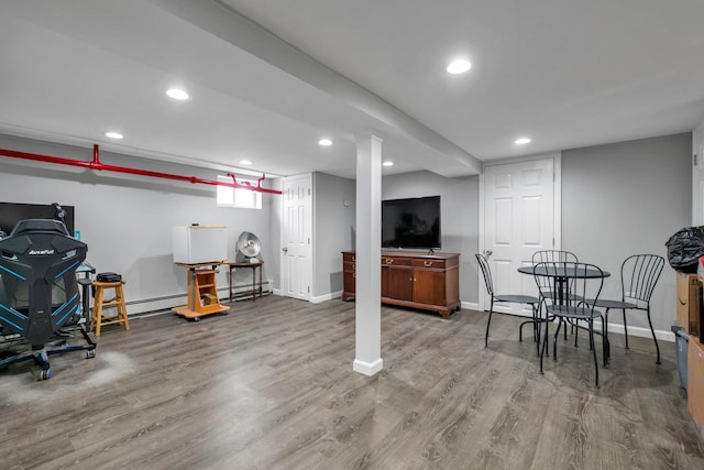 basement with a baseboard radiator, baseboards, wood finished floors, and recessed lighting