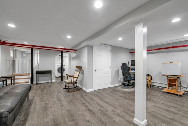finished below grade area featuring wood finished floors, recessed lighting, and washer / dryer