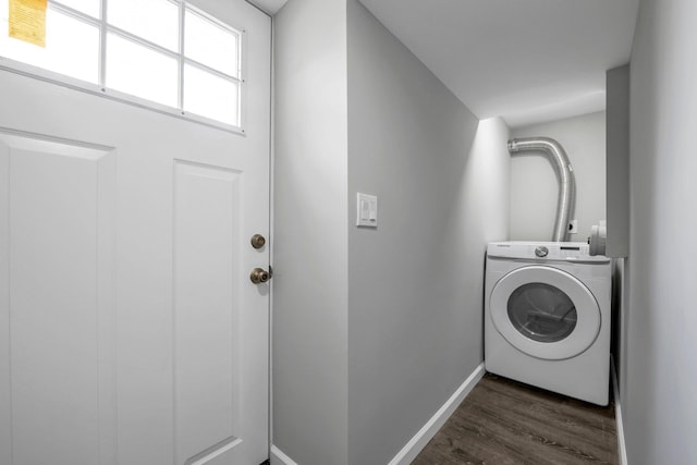 clothes washing area featuring dark wood-style floors, baseboards, laundry area, and washer / clothes dryer