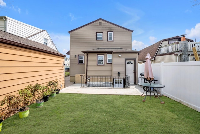 back of house featuring a lawn, a fenced backyard, and a patio