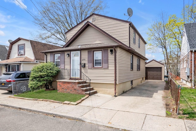 view of front of house with a garage, an outbuilding, fence, and concrete driveway