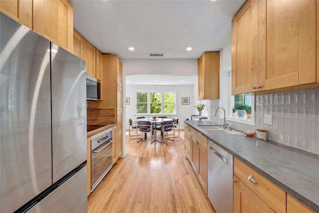 7 Senate Pl, Larchmont, NY 10538 - kitchen with appliances with stainless steel finishes, light wood finished floors, dark countertops, a sink, and recessed lighting