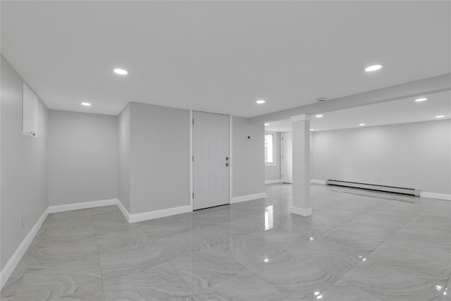 below grade area with baseboard heating, recessed lighting, baseboards, and light marble finish flooring