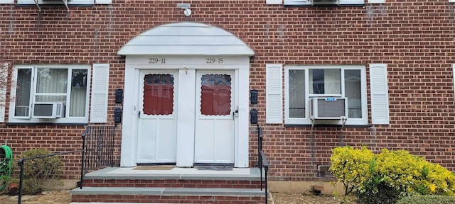 entrance to property featuring brick siding and cooling unit