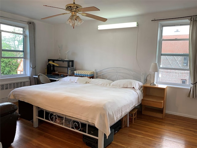 42-40 Bowne St Unit 6D, Flushing, NY 11355 - bedroom with radiator, wood finished floors, a ceiling fan, and baseboards