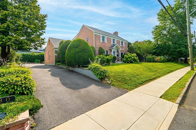 view of property exterior featuring brick siding and a yard