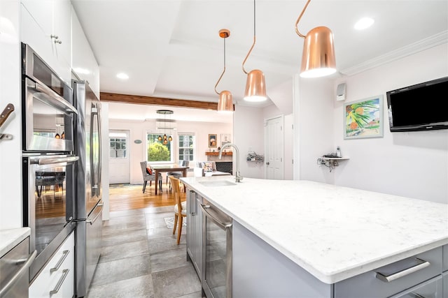 kitchen with hanging light fixtures, a sink, a kitchen island, wine cooler, and recessed lighting
