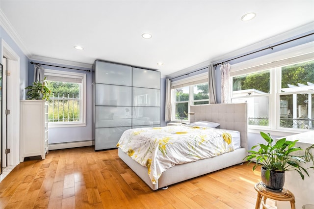 bedroom featuring a baseboard radiator, recessed lighting, crown molding, and light wood-type flooring