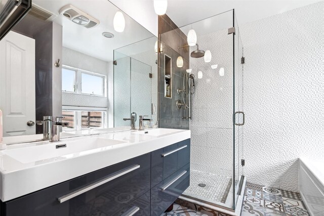 full bath with a sink, a bathtub, double vanity, visible vents, and a shower stall