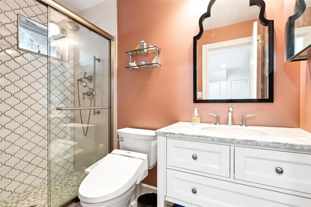 full bath with vanity, toilet, and a stall shower