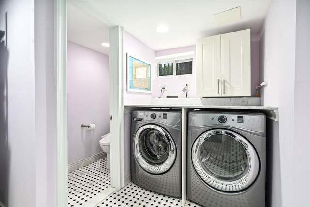clothes washing area featuring cabinet space and washer and dryer