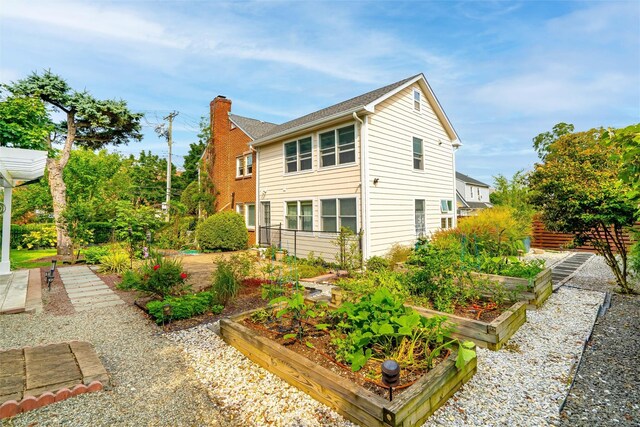 view of home's exterior with a vegetable garden and a chimney