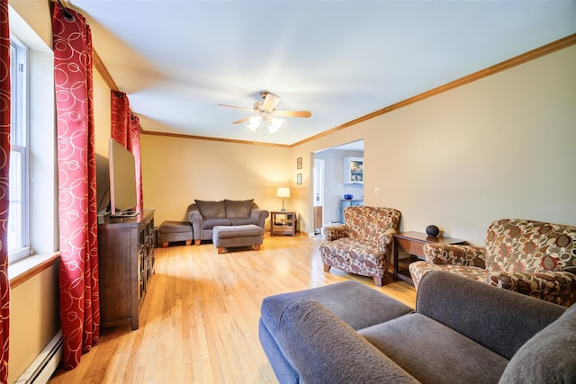 living room with light wood finished floors, ceiling fan, baseboard heating, and ornamental molding
