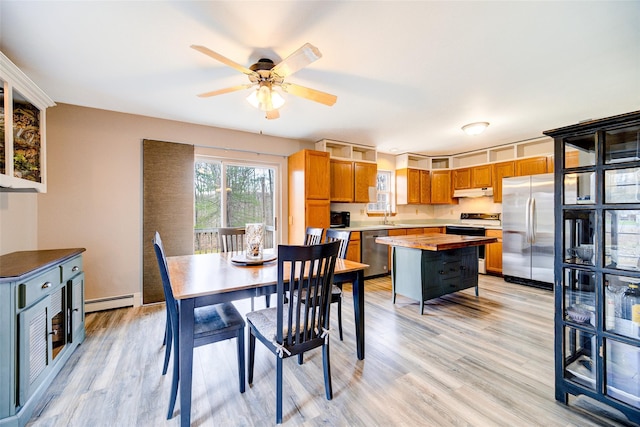 dining room featuring baseboard heating, a ceiling fan, and light wood-style flooring