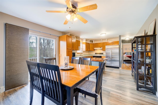 dining room with ceiling fan and light wood-type flooring