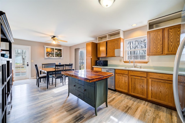 kitchen with brown cabinetry, wood counters, a sink, and appliances with stainless steel finishes