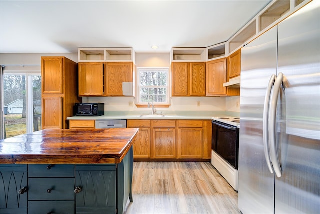 kitchen with under cabinet range hood, stainless steel appliances, open shelves, a sink, and light wood-type flooring