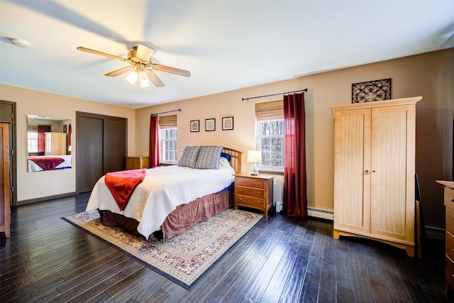 bedroom featuring a baseboard heating unit, ceiling fan, and dark wood-type flooring