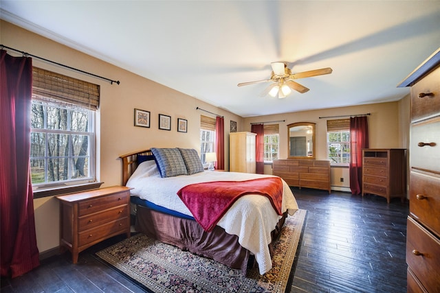 bedroom featuring dark wood finished floors, a baseboard radiator, and ceiling fan