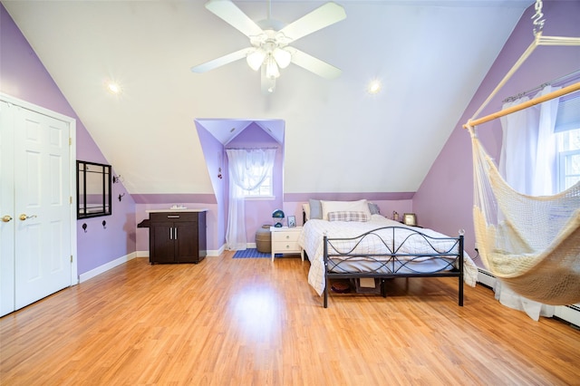 bedroom featuring lofted ceiling, light wood finished floors, and multiple windows