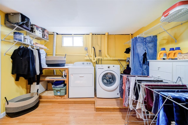 washroom with wood finished floors, washing machine and clothes dryer, and laundry area