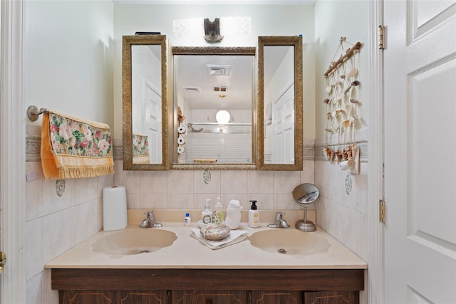 bathroom featuring decorative backsplash, visible vents, a sink, and double vanity