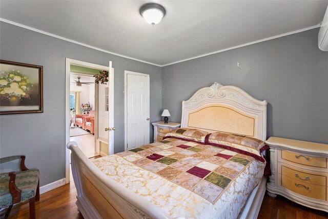 bedroom featuring baseboards, ornamental molding, dark wood-style floors, and a wall unit AC