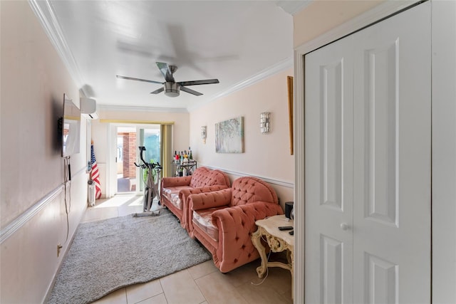 living room featuring light tile patterned flooring, ceiling fan, a wainscoted wall, and ornamental molding