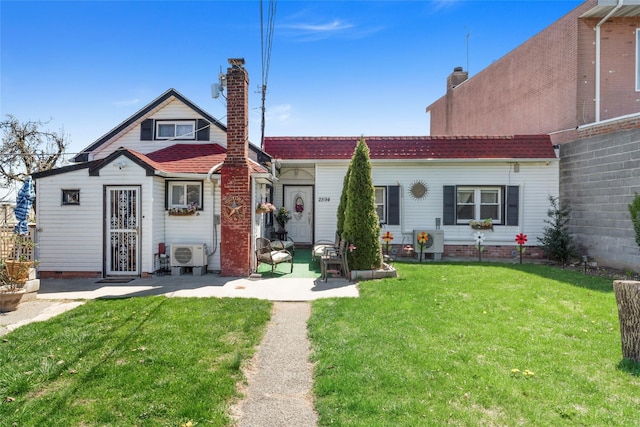back of house with a chimney, ac unit, and a yard