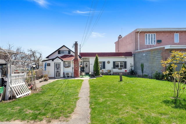 rear view of house featuring a lawn and fence