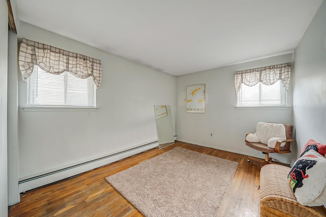 living area with hardwood / wood-style flooring and baseboard heating