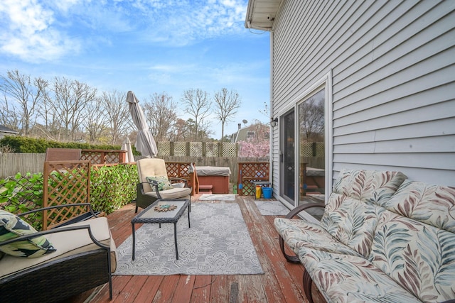 deck featuring fence and a hot tub