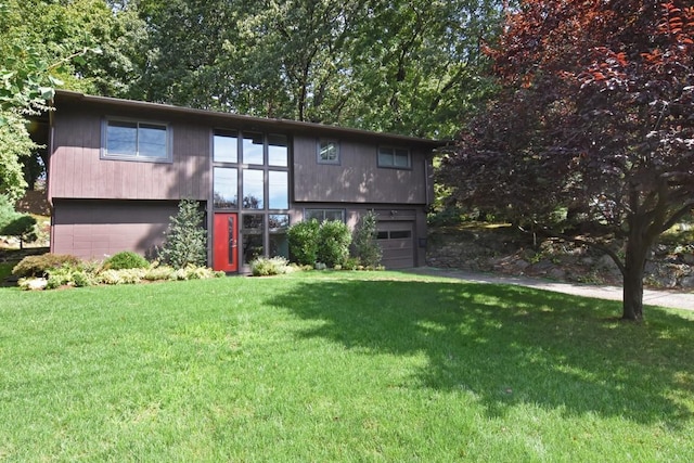 bi-level home featuring a front lawn and a garage