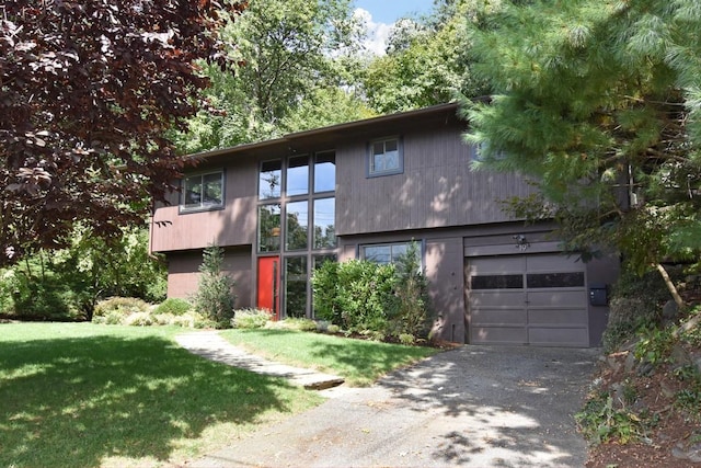 view of front facade with a front lawn, aphalt driveway, and a garage